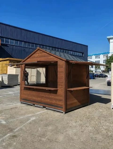 Caseta de madera montada al aire libre a pleno día, con las ventanas abiertas